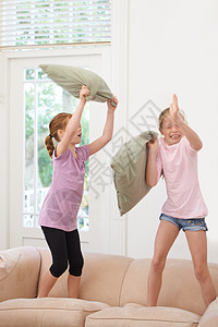 看来是时候做枕头搏斗了 两个姐妹在沙发上玩图片