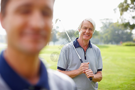高尔夫俱乐部和笑容的老人长相 高尔夫俱乐部 与儿子一起微笑在前台图片