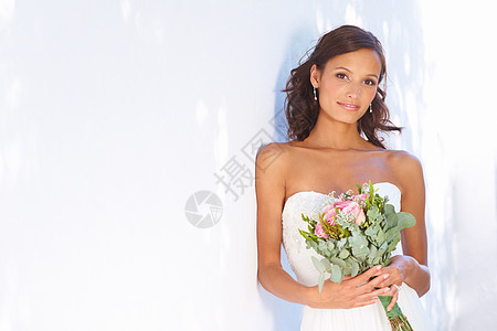 她是他要找的 一位美丽的新娘站在外头拿着花束站着图片