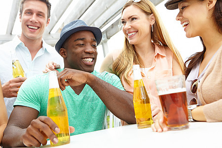一群朋友在热闹的户外餐厅的甲板上喝着饮料 享受着饮品图片