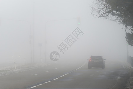 汽车在雾蒙蒙的路上行驶 车头灯或前灯亮着 低能见度冬季恶劣天气下危险驾驶汽车沥青森林头灯车辆交通大灯季节速度运输阴霾图片