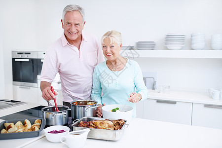 一对年长的夫妇在厨房愉快地一起做饭 复制版空间 我很高兴能和你共进晚餐图片