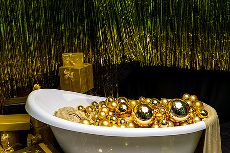 充满金球的浴缸 盛装着节日金球的闪亮古老浴室 新年 圣诞洗手间室内建筑学风格装饰酒店小木屋淋浴地面财产小屋奢华图片