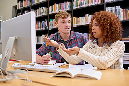 他们正准备在期中考试中取得好成绩 两名学生在大学图书馆的电脑前一起工作背景图片