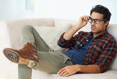 一个美丽的时尚的年轻人躺在沙发上 双腿穿透了戴眼镜的浴缸里 穿着眼镜图片