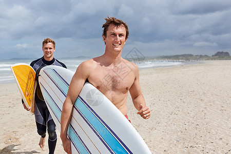 冲浪不仅仅是振奋人心 年轻冲浪者对冲浪兴奋不已男人男性微笑太阳训练成人海滩沙滩海滨冲浪板图片