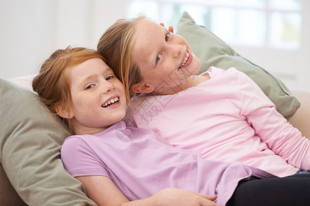 姐妹们是最好的朋友 两个年轻姐妹的肖像躺在沙发上的家中红发休闲装俏皮喜悦女性兄弟朋友青年童年想像力图片
