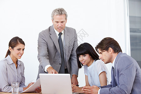领导才能对于将他们的想法纳入一个计划至关重要 一个商界人士团队一起在笔记本电脑上工作图片