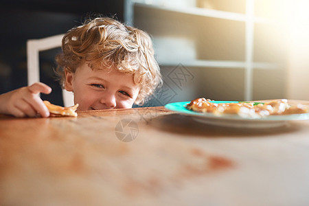 小孩可以随时进玩耍的时间 一个可爱的小男孩在家里吃东西图片