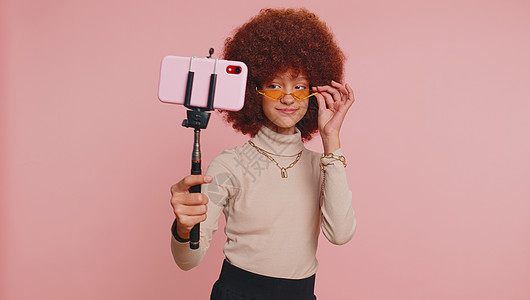 使用智能手机与订户在线视频电话进行连线的视频通话时采取自拍女学生记录影响者媒体互联网照片粉红色娱乐孩子们微笑图片