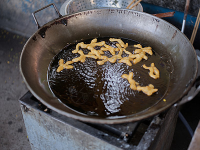 在一个大油锅里切下深炸中国甜甜圈子甜点烹饪食物手工美味营养面团小吃饮食糕点图片