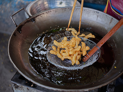 在一个大油锅里切下深炸中国甜甜圈子面团饮食美味小吃面粉美食糕点面包甜点早餐图片