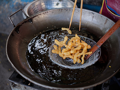 在一个大油锅里切下深炸中国甜甜圈子糕点食物小吃面包美食面团甜点油炸面粉烹饪图片