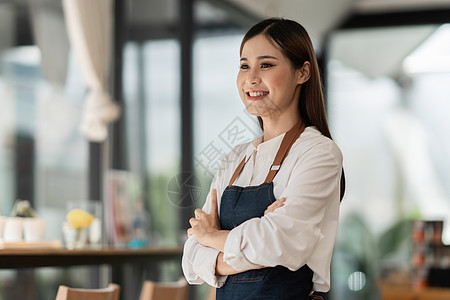 成功的小商主在咖啡馆站着的美貌女孩工作商业工人食堂咖啡师女性职业员工经理围裙图片