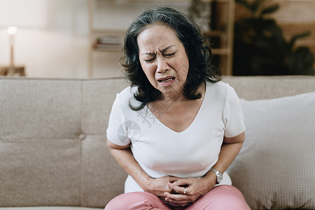 80年代的亚裔女性 精疲力竭和压力下 在家中肚子痛病人孤独保健疼痛退休药品治疗成人帮助医院图片