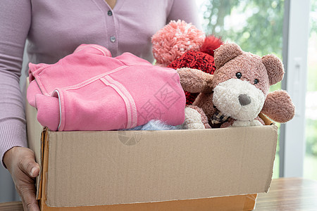 在家里拿着装有旧衣服和洋娃娃的衣物捐赠箱 支持帮助世界上的穷人送货娃娃衣柜服务包装服装分发头脑贫困世界图片