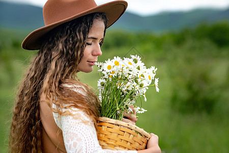 怀着白裙子和棕帽子的中年妇女手里握着一束盛大的花朵 祝贺之野花植物花束甘菊花园乡村雏菊园艺季节荒野生活图片