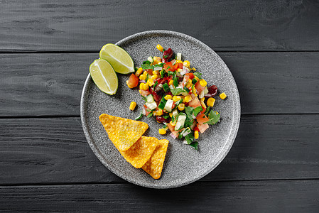 黑色木制背景上的德克萨斯鱼子酱 顶视图 灰色盘子里放着薯条和玉米片的德州菜 减少饮食 弹性饮食 鱼素饮食图片