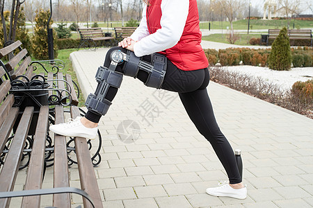 妇女在腿外科手术后膝膝部或矫形 在公园中行走支撑疼痛绷带事故药品成人训练矫形器治疗夹板图片