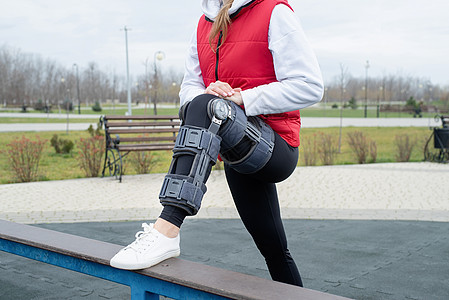 妇女在腿外科手术后膝膝部或矫形 在公园中行走支撑成人保健训练事故运动治疗师肌腱膝盖矫形器图片
