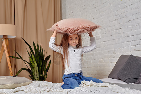 在床上用枕头 画着可爱感动的小姑娘的肖像赤脚行动裙子女儿童年女性孩子们孩子幸福女孩图片