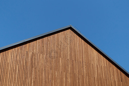 在新的现代房子的屋顶上 与蓝色晴蓝天空相对 复制空间背景图片