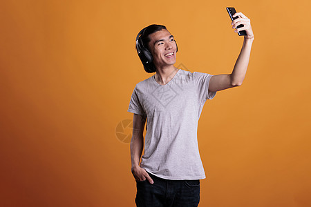 亚洲青少年在智能手机前摄像头照相机上拍照高清图片