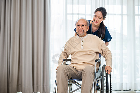 医生在医院推推轮轮椅和经营老年残疾病人自由举臂扶助图片