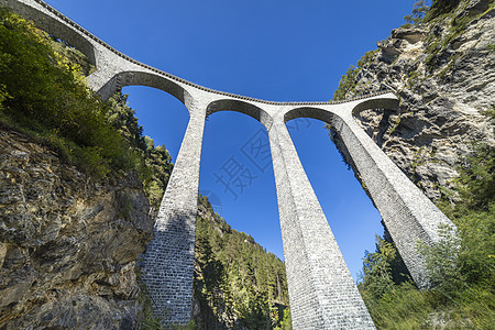 瑞士列车经过瑞士格劳本登阿尔卑斯山桥运输晴天旅游火车站目的地建筑学悬崖文化地方低角度图片