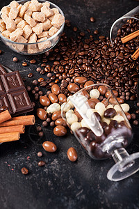来自不同类型糖果的成分花生早餐豆子肉桂巧克力包子木板玻璃桌子杯子图片