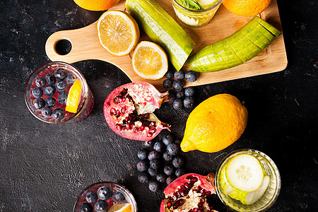 水果 蔬菜和浆果的顶端景色 玻璃杯旁有脱毒水柠檬蓝色温泉黄瓜石榴液体玻璃食物维生素饮料图片