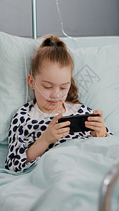 儿童游戏生病的小孩在床上休息 用智能手机在线游戏电子游戏视频保健孩子药物病人药品诊断呼吸咨询微笑背景