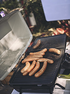 新鲜香肠和热狗在户外烧烤图片