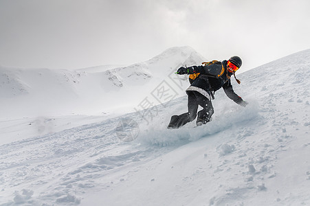滑雪板 一名年轻女子在山上的滑雪板上运动 在距离滑雪场不远的地方自由滑雪 进行下坡滑雪图片
