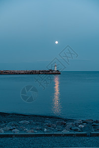 满月升起到灯塔 月亮之路不是海海岸线岩石海景月光安全蓝色橙子导航航行码头图片