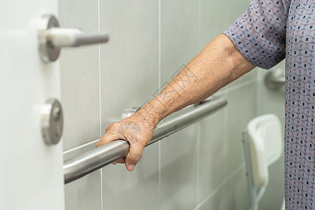 亚洲老年或老年老妇人病人在护理医院病房使用厕所浴室手柄安全 健康强大的医疗理念座位淋浴洗手间退休金属房间洗澡酒店合金潮红图片