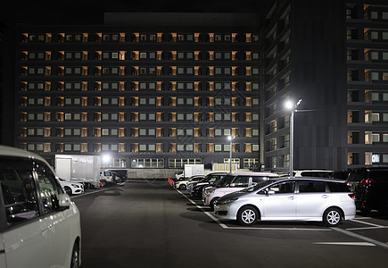 晚上在多层旅馆大楼旁的全停车场图片