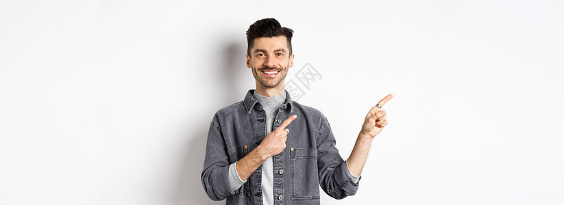 笑笑的帅帅男人左手指着手指 显示标志 看相机欢快 白背景广告等夹克商业工作室办公室成人胡子标识白色发型快乐图片