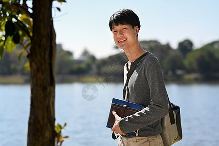 站在湖边的男学生肖像 背景是群山阳光明媚的风景 自然界中的人与休闲图片