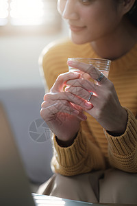 在家喝杯水时用笔记本电脑工作的漂亮商业女商务人士;和图片