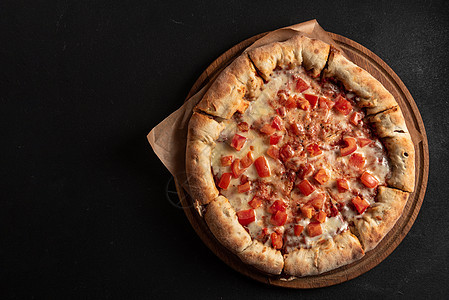 那不勒斯披萨配香料 西红柿和深色背景上的马苏里拉奶酪 玛格丽塔比萨配马苏里拉奶酪 番茄酱 菠菜和厚面团 顶视图传统美食垃圾糕点食图片