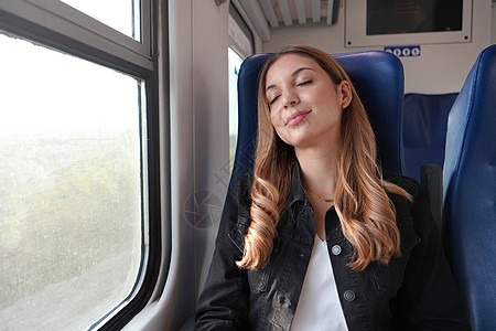 秋季秋天在公共交通工具上睡觉的美丽的妇女和铁路游客微笑车站女孩座位窗户运输商业乘客图片