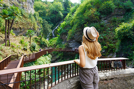 女孩走在享有风景 瀑布和天然峡谷峡谷峡谷的道路上丛林热带旅游荒野公园小路流动野生动物鸿沟一缕阳光图片