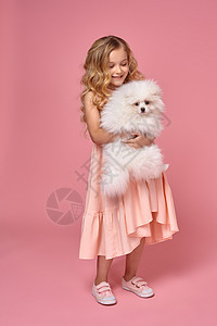 儿童游戏小女孩 金发卷毛金发 穿粉红裙子 和她的狗玩毛皮游戏友谊活动乐趣朋友女孩小狗微笑眼睛背景