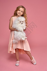 儿童游戏小女孩 金发卷毛金发 穿粉红裙子 和她的狗玩宠物玩家朋友女性吉祥物眼睛乐趣拥抱微笑卷曲背景