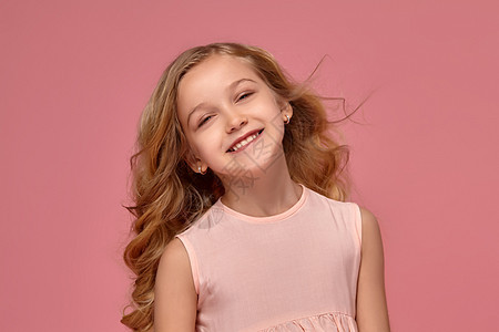 穿粉红裙子的小女孩 金发卷发 穿着粉红色礼服乐趣青少年眼睛童年头发微笑卷曲孩子诡计衣服图片