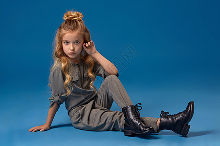 穿着时装长卷发的小女孩 穿着时尚服装衣服金发女郎沙龙广告靴子女儿姿势消费者卷曲服饰图片
