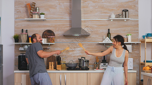 夫妻在厨房玩得开心剑术女朋友两个人快乐食物钢包生活亲热厨具勺子图片