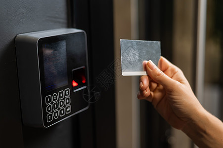 一个女人用塑料卡打开门 现代的无钥匙入口锁展示控制机器住宿保障办公室安全鉴别传感器技术图片