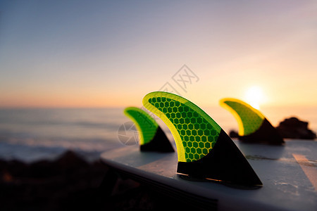 日落时海滩上冲浪板的鳍图片